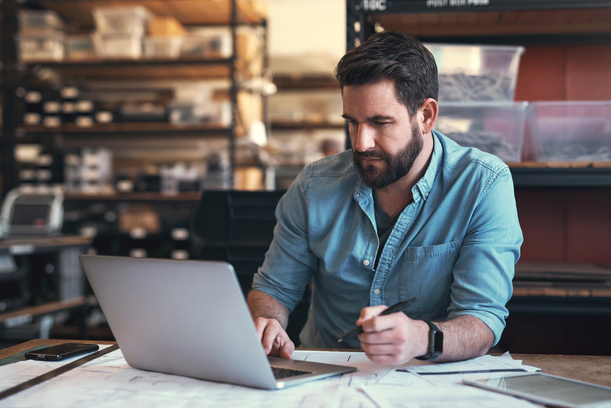Contractor using a field service software on his laptop to scale his business